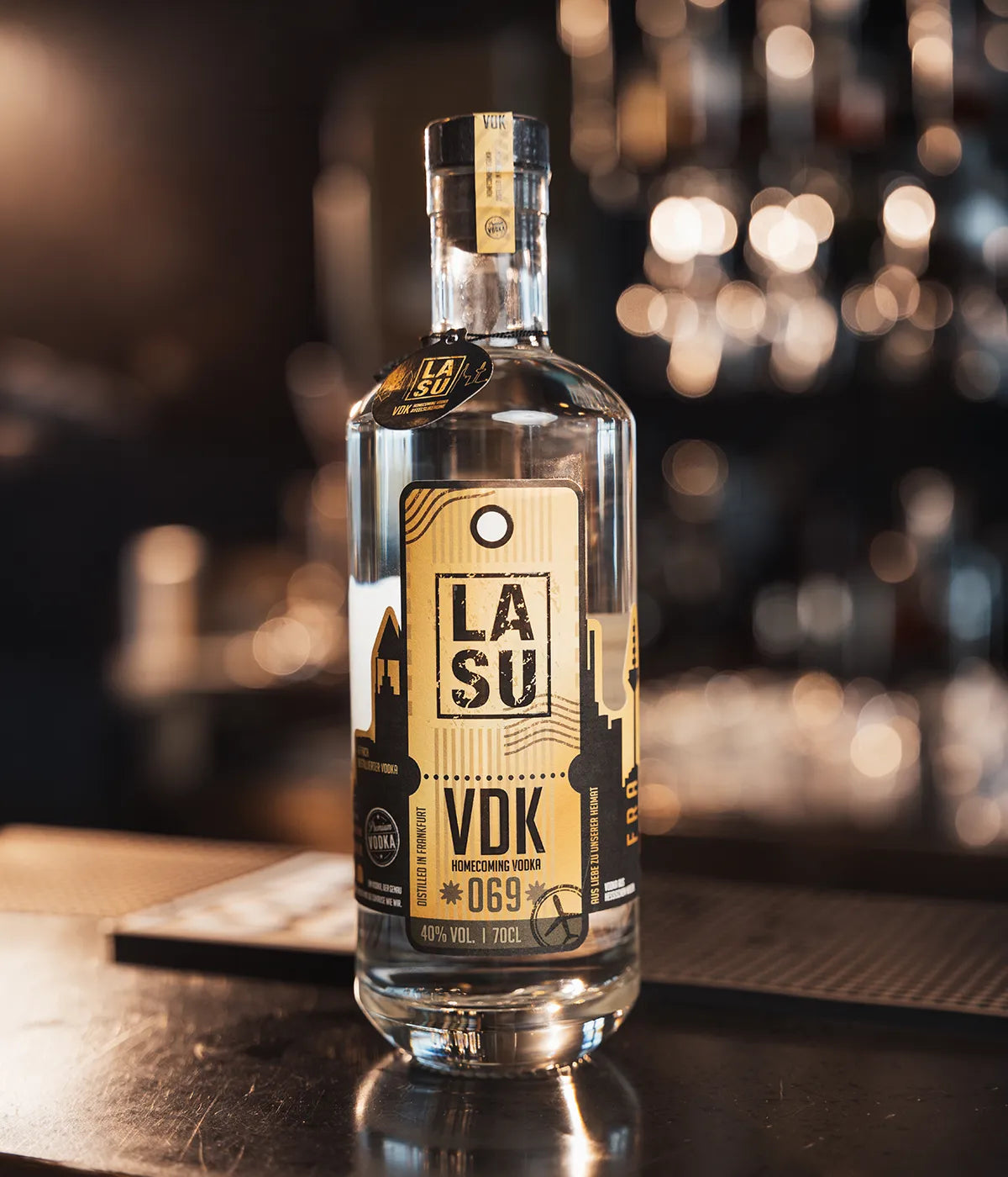 LA SU VDK Flasche auf Bartresen mit warmem Bokeh-Lichterhintergrund