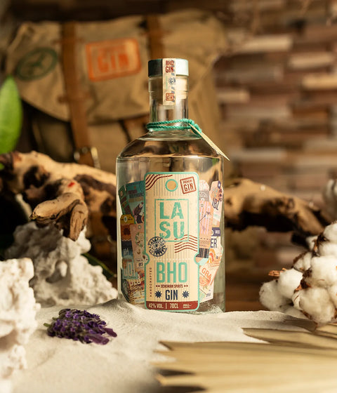 LA SU BHO Flasche zwischen Treibholz, Sand, Baumwollzweig und Lavendel