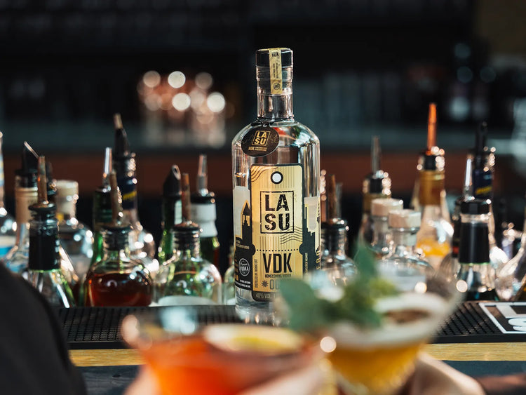 LA SU VDK Flasche zwischen Bar-Flaschen, Cocktails im Vordergrund