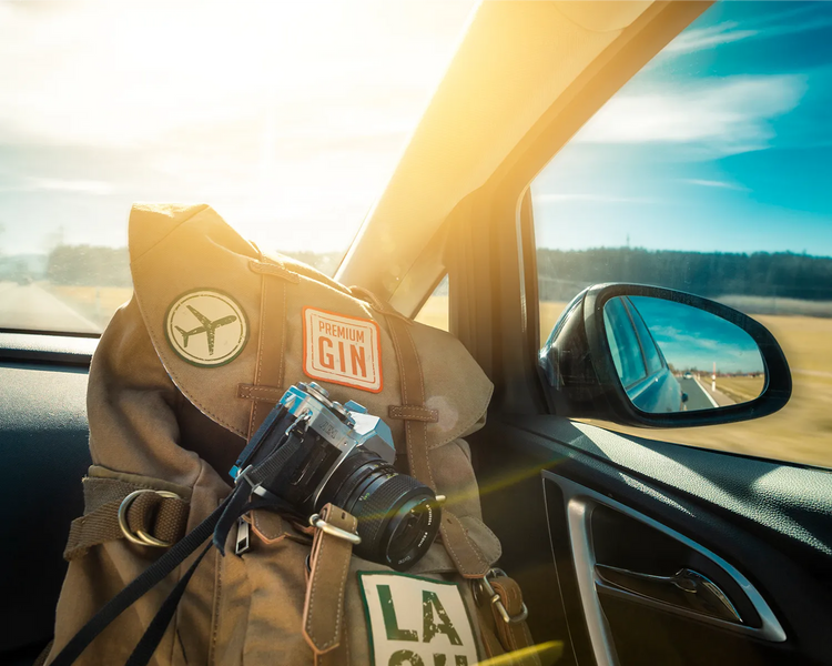 Reisetasche mit LA SU Patch und Kamera im Auto, Roadtrip bei Sonnenuntergang